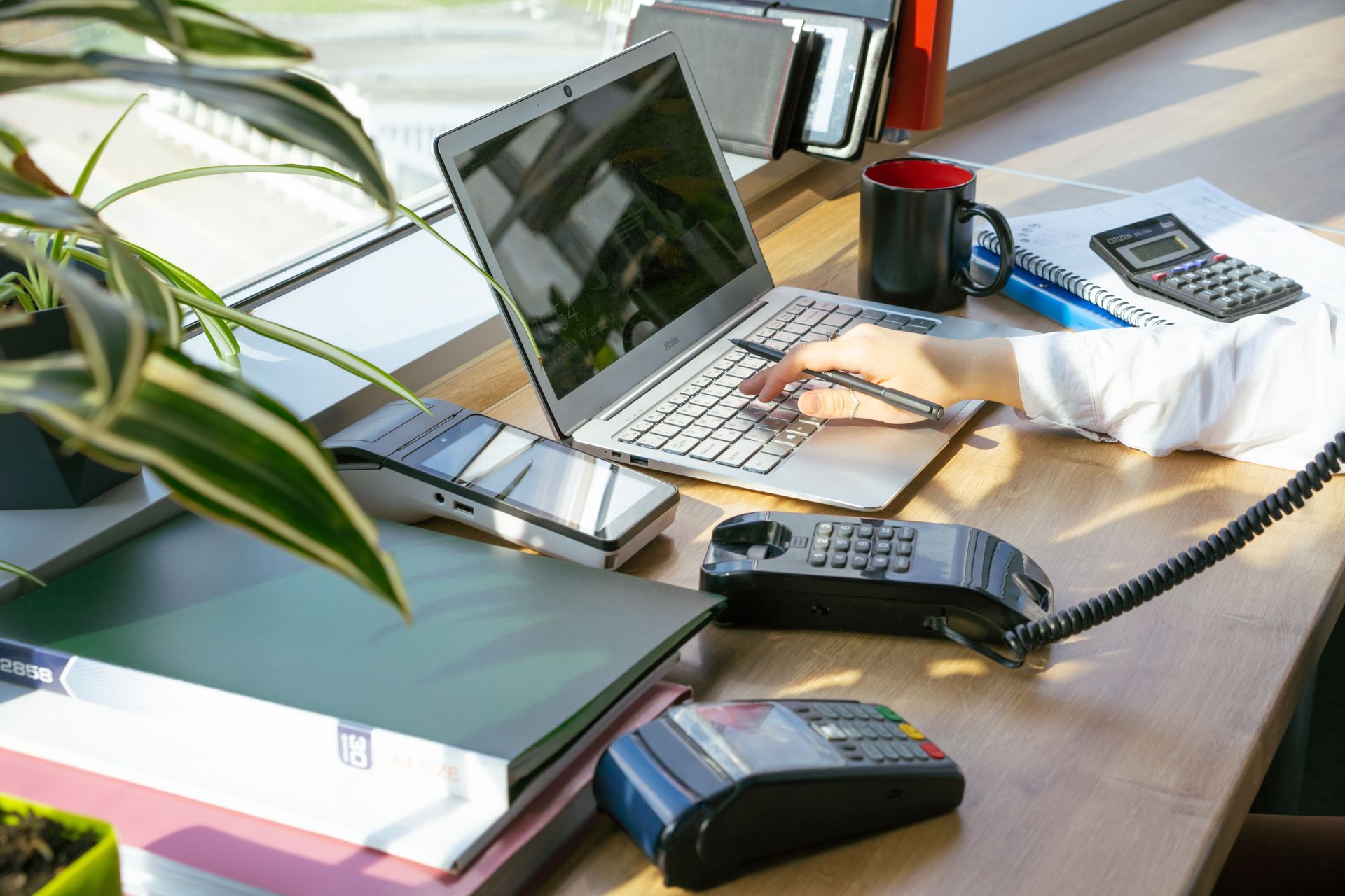 A bright modern office desk setup with electronic devices and plants, ideal for productivity.